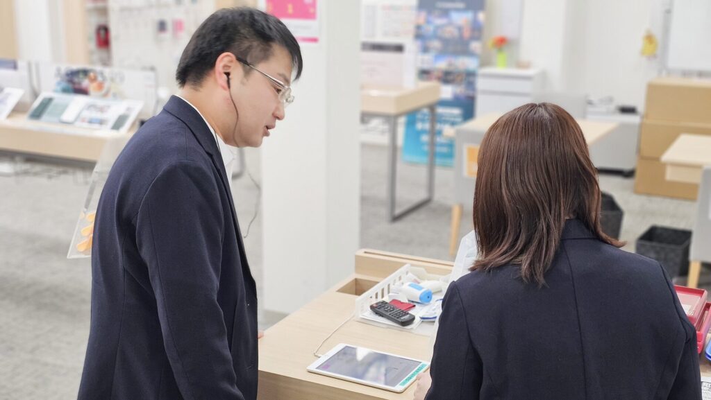 スマホの設定をしているドコモショップ店員