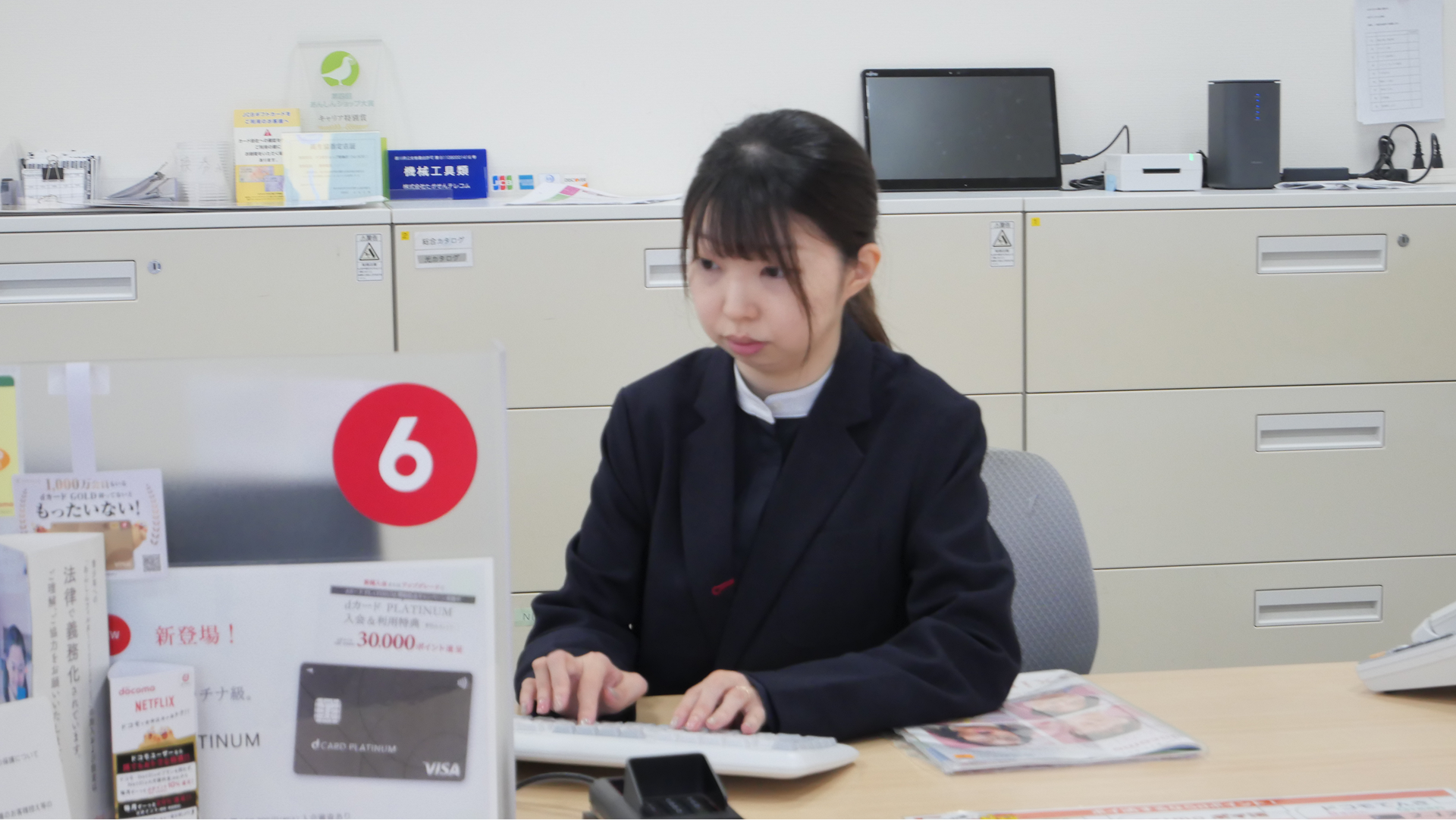 パソコン作業をするドコモショップ店員